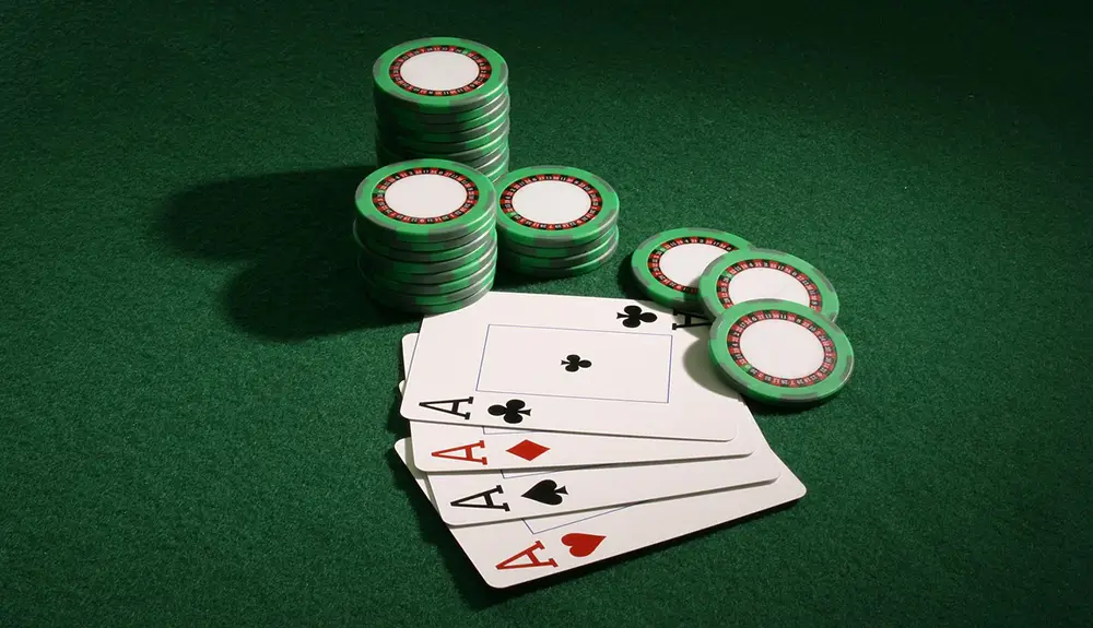Quatre as avec des jetons blancs sur une table de poker