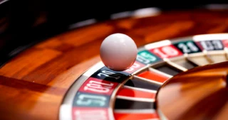 Bille reposant sur la roue de roulette européenne à un seul zéro, vue rapprochée de la table de casino.